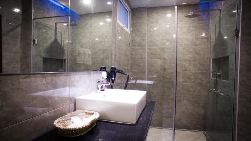 a bathroom with a sink and a glass shower at Family Boutique Hotel in Vientiane