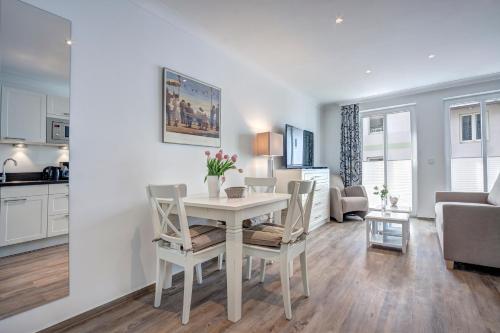 a kitchen and living room with a table and chairs at Aparthotel Villa Lea in Ahlbeck