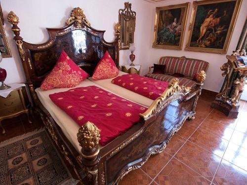 a large wooden bed with red pillows in a room at Rittergut Haus Laer in Bochum