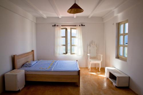 a bedroom with a bed and a window and a chair at Dembelija Rooms in Virpazar