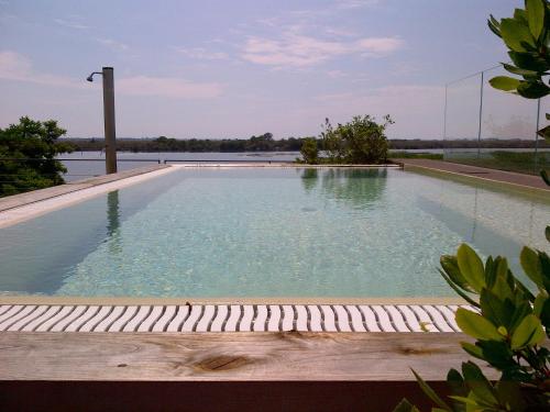グラードにあるBoutique Hotel Oche Selvaticheの水の景色を望むスイミングプール