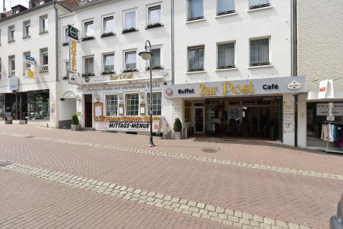 a city street with buildings on a brick road at Hotel zur Post Kleve in Kleve