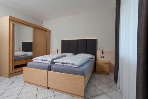 a bedroom with a bed with a large mirror at VillaGiardino - Lake in Molveno