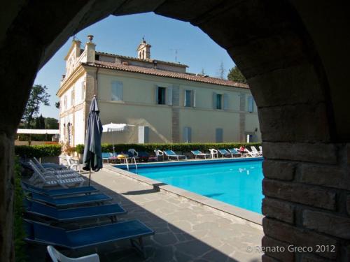 a view of a building and a swimming pool at Hotel Villa San Donino in Città di Castello