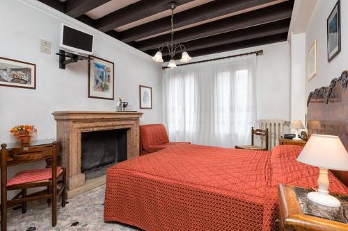 1 dormitorio con cama roja y chimenea en Villa Albertina, en Lido de Venecia