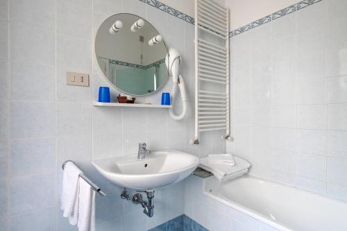 a white bathroom with a sink and a mirror at Villa Albertina in Venice-Lido