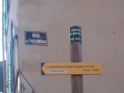two signs on a pole in front of a building at L'Espaviot aux portes du Puy en Velay in Espaly-Saint-Marcel