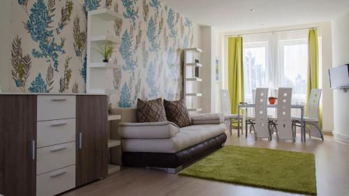 a living room with a couch and a dining room at Hotel Forras in Komárom