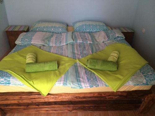 łóżko z dwoma zielonymi poduszkami w obiekcie Holiday Home Green House w mieście Batina