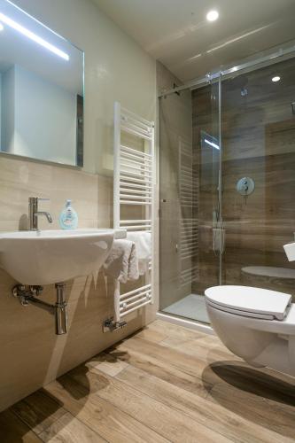 a bathroom with a sink and a toilet and a shower at VillaGiardino - Lake in Molveno