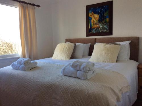 a bedroom with two beds with towels on them at Ashbank Hotel in Carradale