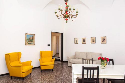 a living room with yellow chairs and a table at Casa Carducci - Spacious historical home close to the beach in Imperia