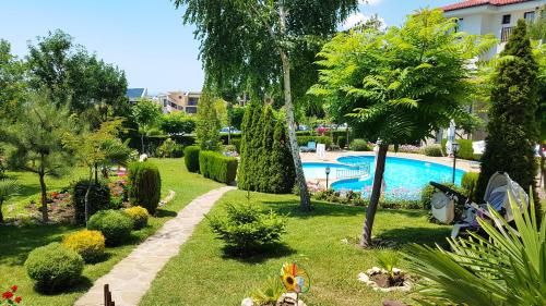 a view of a garden with a swimming pool at Delfin Port Apartments - Prime Location & Parking & Pet Friendly in Sveti Vlas