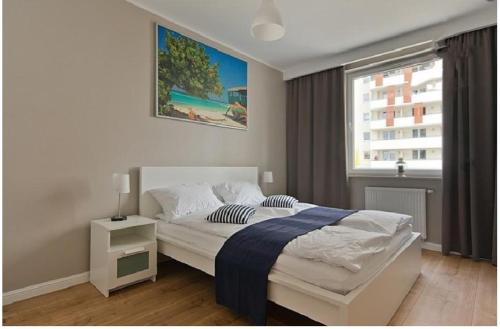 a bedroom with a bed and a window at Apartament blisko morza in Gdańsk