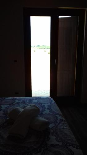 a bedroom with a bed and a window and a door at Agriturismo Villa Cascignoli in Roseto degli Abruzzi