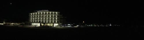 a tall building at night with lights on it at Stellamare in Caorle