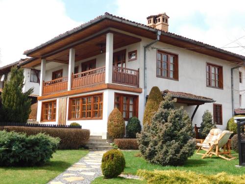 a large white house with a balcony at Family Vacation Home Topolnitza in Koprivshtitsa
