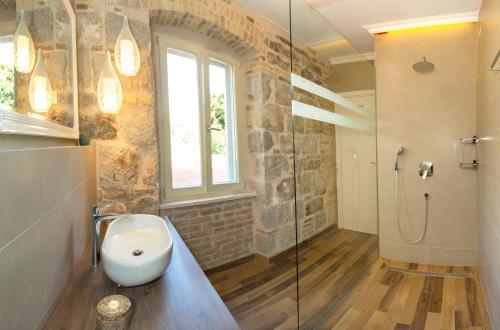 a bathroom with a sink and a glass shower at Aspalathos Residence in Split