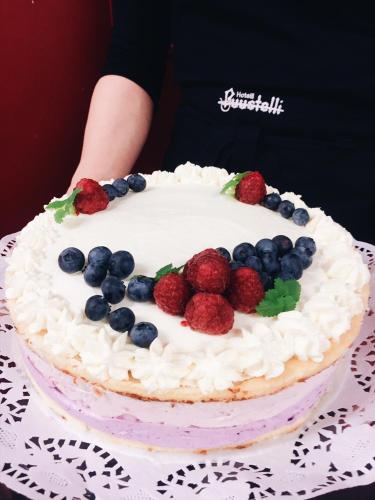 a cake with berries on top of it on a table at Hotelli Puustelli Lieksa in Lieksa