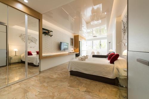 een slaapkamer met een groot bed en een spiegel bij Suites Garden Loft Munch in Las Palmas de Gran Canaria