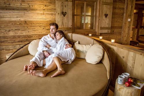 a man and a woman sitting on a couch at Natur-Wohlfühlhotel Brunner Hof in Arnschwang