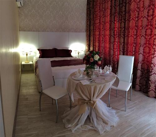 a room with a table, chairs and a dresser at Art Hotel in Tikhoretsk
