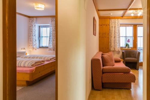 サンクト・ジョアン・イン・チロルにあるAppartement Seiblのベッドルーム1室(ベッド1台、椅子付)