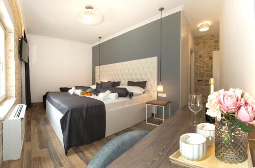 a bedroom with a bed and a table with flowers at Aspalathos Residence in Split