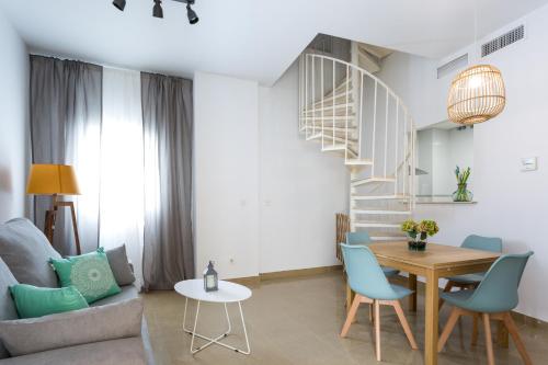 sala de estar con mesa y sillas azules en Apartamentos Alberto Lista 9, en Sevilla