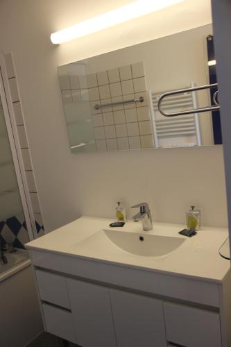 a white bathroom with a sink and a mirror at Les Thermes in Dax