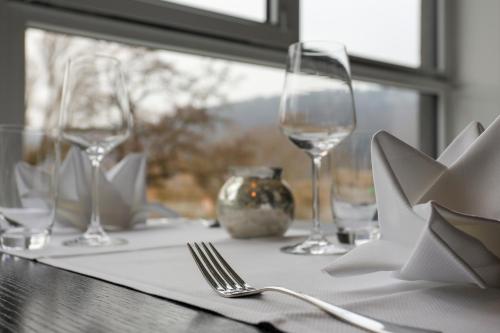 a table with two wine glasses and a napkin at FourSide Plaza Hotel Trier, Trademark Collection by Wyndham in Trier