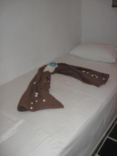 a bed with a hat on top of it at Pension Irini-Vicky in Ios Chora