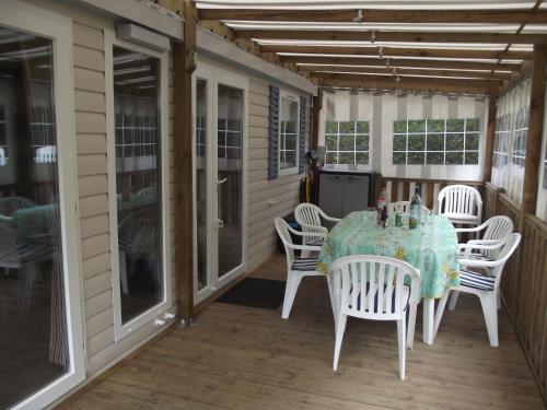 a table and chairs on a screened porch at Les Charmettes Mobilhomes17 in Les Mathes