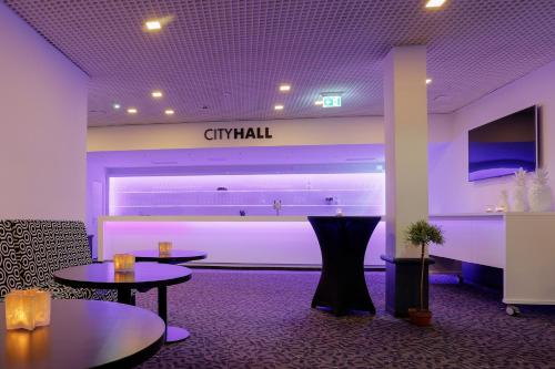 a lobby with two tables and a sign that reads criminal at FourSide Plaza Hotel Trier, Trademark Collection by Wyndham in Trier
