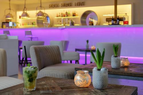a dining room with purple lighting and tables and chairs at FourSide Plaza Hotel Trier, Trademark Collection by Wyndham in Trier