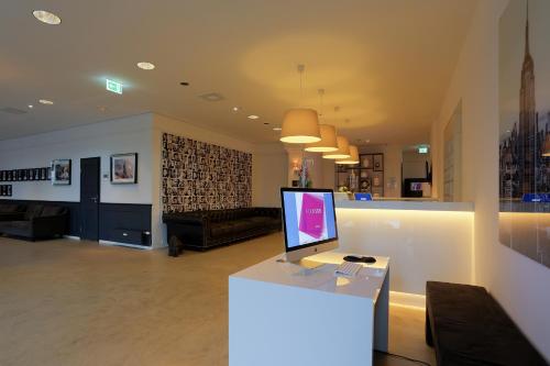 a living room with a counter with a computer on it at FourSide Plaza Hotel Trier, Trademark Collection by Wyndham in Trier