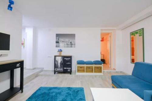a living room with a blue couch and a tv at Apartment Fontana in Belgrade