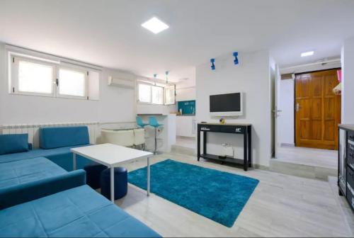 a living room with a blue couch and a table at Apartment Fontana in Belgrade