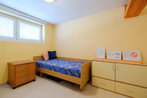 a bedroom with a bed and a dresser and a window at Apartment Fontana in Belgrade