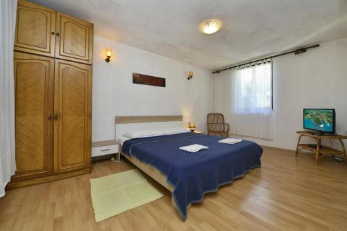 a bedroom with a bed with blue sheets and a cabinet at Villa Funtana in Funtana