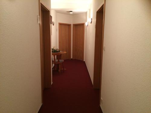 a hallway of a hotel with a table and a room at Zur Krone in Seelze
