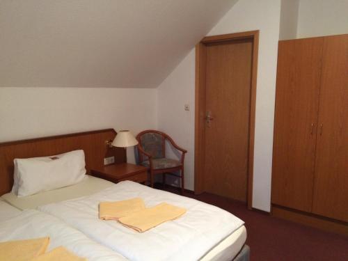 ein Schlafzimmer mit einem Bett mit zwei Handtüchern darauf in der Unterkunft Zur Krone in Seelze