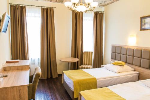 a hotel room with two beds and a table at Nevsky Bereg 93 in Saint Petersburg