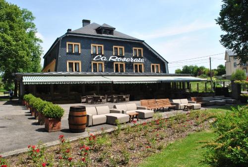a building with couches and tables in front of it at La Roseraie. Gaume-Ardenne-lacuisine sur Semois. in Florenville