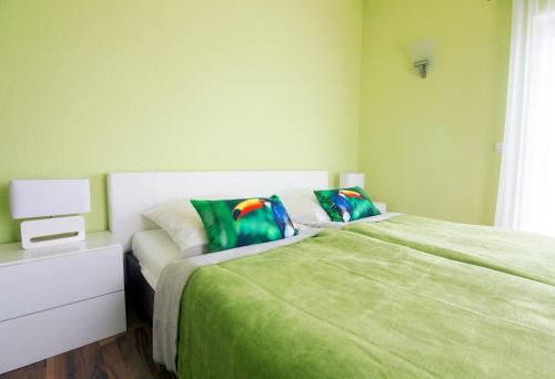 ein Schlafzimmer mit einem grünen Bett und einer weißen Kommode in der Unterkunft Bei Meyers im Leipziger Neuseenland in Großdeuben