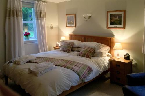 a bedroom with a large bed and a window at Druminoch in Angus