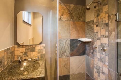 a bathroom with a sink and a shower at Merry Pebbles Resort in Sabie