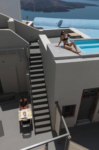 a man and a woman sitting on the roof of a house at Aria Suites & Villas in Fira
