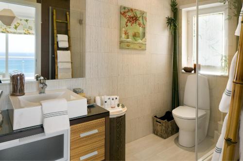 uma casa de banho com um lavatório, um WC e um espelho. em CALI Deluxe Holidays, Sesimbra em Sesimbra