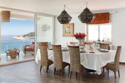 a dining room with a table and chairs and the ocean at CALI Deluxe Holidays, Sesimbra in Sesimbra